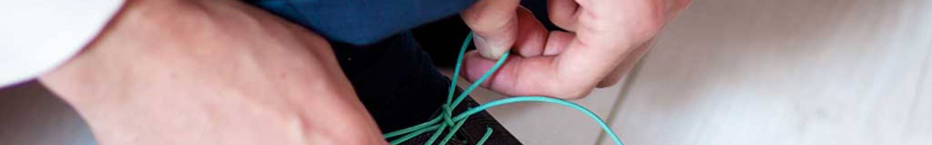 What benefits do waxed laces provide in terms of resistance to water and wear?